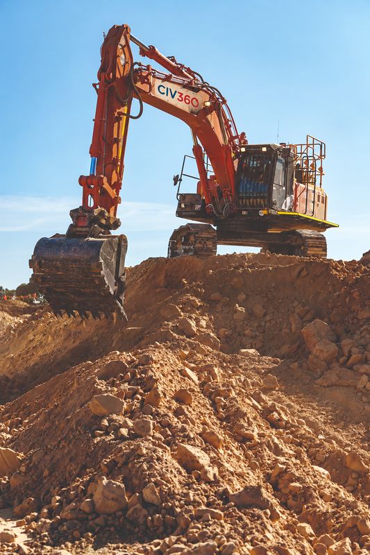 CIV360 excavator on a rock spoil mound with its bucket lowered